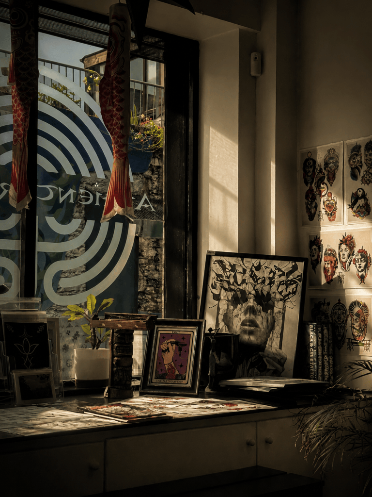 Sunlight falling across tattoo artwork, framed prints and flash designs inside Ancient Rituals tattoo studio in Killarney.