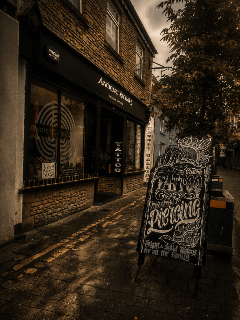 Exterior of Ancient Rituals tattoo studio in Killarney, with a hand-painted tattoo sign on the pavement outside.