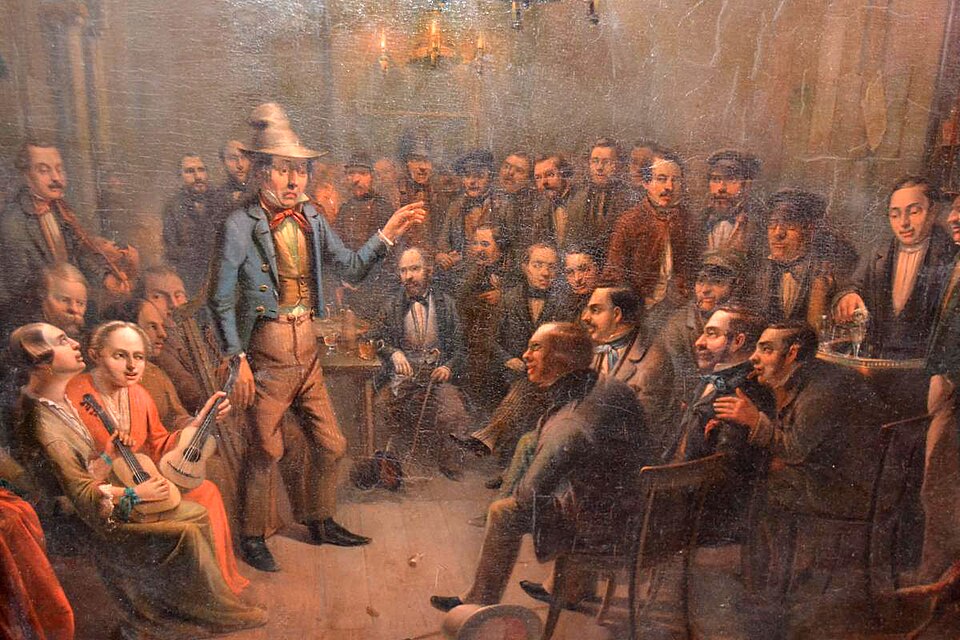 A storyteller standing before a crowded room as people gather around to listen.
