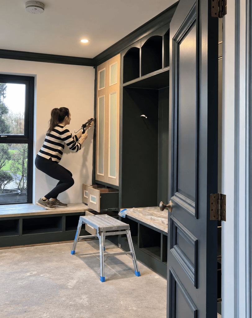 Helen working on the green built-in cabinetry in the boot room at Hatfield House.